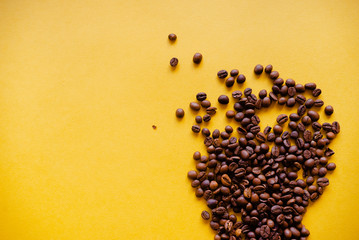 Roasted coffee grains and takeaway cup top view. Craft paper tea cup on orange background flat lay. Cafe web banner with copyspace