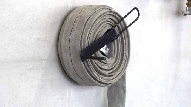 Fire hose reeled up hanging on the wall
