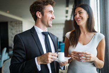 Beautiful young couple talking to each other and smiling while enjoying coffee
