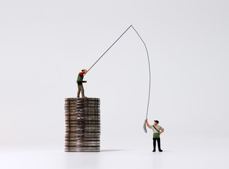 Miniature people fishing and piles of coins. 