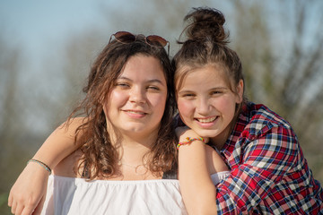 Fototapeta premium portrait of two happy sisters, outdoors