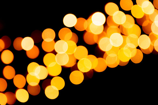 Defocused city gold night bokeh abstract background. blurred many round yellow light on dark background