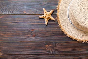 Fototapeta na wymiar Straw hat and starfish On a dark wooden background. top view summer holiday concept with copy space