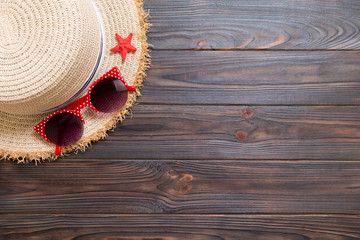 Straw hat, sun glasses and seashells on a dark wooden background. top view summer holiday concept with copy space
