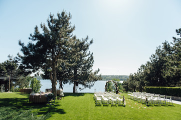 beautiful arch for the wedding ceremony in the park with white chairs for guests