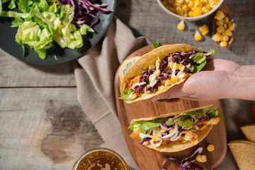 Traditional mexican taco with chicken and vegetables on wooden table. Latin american food.
