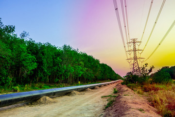 Natural gas pipe line on silhouette sunset sky, Electricity pylon with shadow of tree in dawn time, Electricity pylon with on orange sky