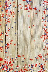 The national holiday of July 14 is a happy Independence Day of France, Bastille Day, the concept of patriotism, memory, place for text, confetti on a wooden table. vertical