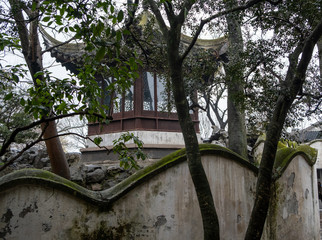China, Suzhou, Humble Government Park pavilion with red wood walls , hidden on trees and white wall
