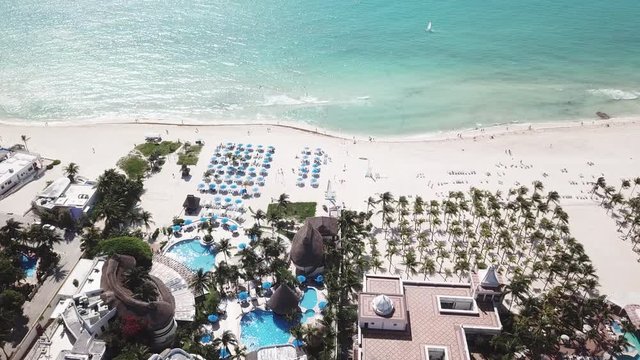 Top view of beautiful beach. Aerial drone shot of turquoise sea water at the beach. Luxury tropical resort with white sand. Aerial view