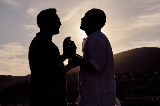 a gay interracial couple at sunset
