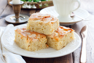 Homemade Apple Pie with Almond Petals on a wooden table, horizontal