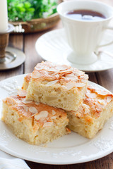 Homemade Apple Pie with Almond Petals on White Crockery, selective focus
