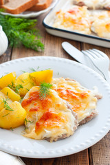 Pork chop with cheese and potatoes on a wooden table, selective focus