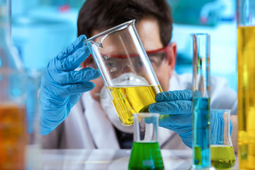 researcher measuring sample in beaker of liquids in the research lab