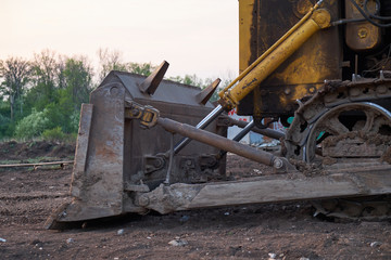 Fototapeta na wymiar Yellow tracked tractor with lowered shovel