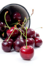 White cup with red sweet cherry isolated on a white background..