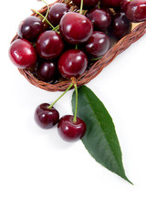 Yellow wooden basket with red sweet cherry isolated on a white background..