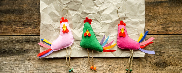 Rustic background with funny felt toys. Happy handmade toys cocks 