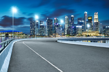 Fototapeta na wymiar High speed corner overpass asphalt road with Singapore cityscape , night scene .