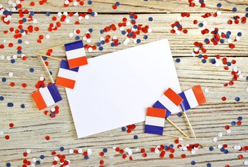 The national holiday of July 14 is a happy Independence Day of France, Bastille Day, the concept of patriotism, memory, place for text, confetti and flags on a wooden table. horizontal, mocup