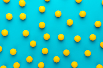 many balls for table tennis on turquoise blue background. flat lay image of many yellow ping-pong...