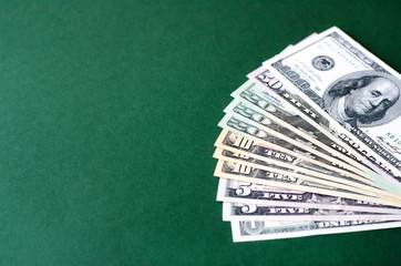 A stack of dollar bills on a green background.