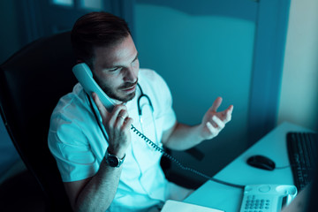General practitioner talking with a patient over the phone.