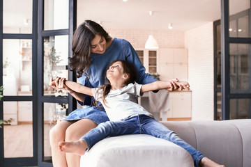 Happy mother and daughter having fun at home