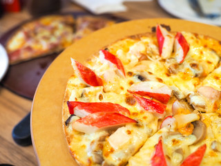 Delicious pizza served on wooden plate