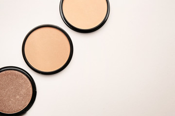 Different facial powder on light background