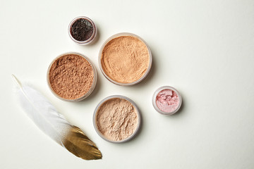 Different facial powder on light background