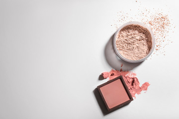 Blusher and facial powder on light background