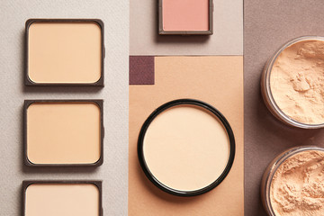 Different facial powder on color background