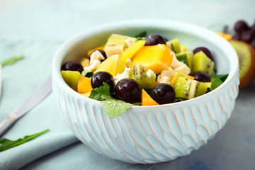 Bowl with tasty mango salad on table