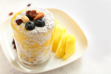 Glass with tasty mango and chia dessert on table