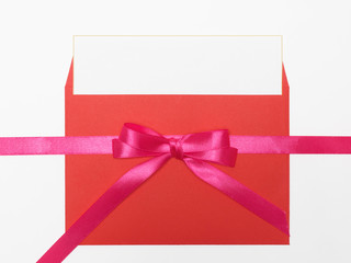 Pink ribbon, bow with two loops, orange envelope on white background