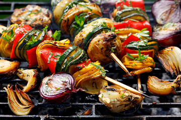 Vegetarian skewers, grilled vegetable skewers of zucchini, peppers and potatoes with the addition of aromatic herbs and olive oil on the grill outdoors. Grilled food - 269353512
