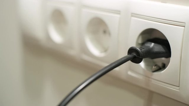 Male hand pulling electrical plugs from sockets
