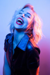 Attractive laughing woman dressed in fashion apparel in neon night lights.