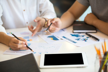 Close up of hands and stationery of Business people counting on calculator sitting at the table