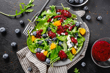 Summer salad with salad leaves, fruits, berries and cheese