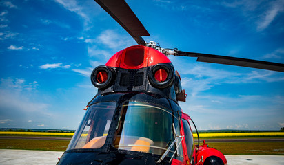 red and black helicopter standing at the airfield close up © Dismollstock