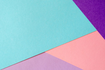 Multicolored paper background in soft blue, violet, lilac and coral colors.