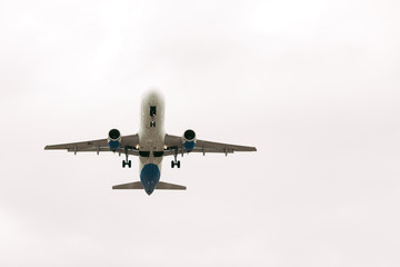 White passenger airplane flies against the sky