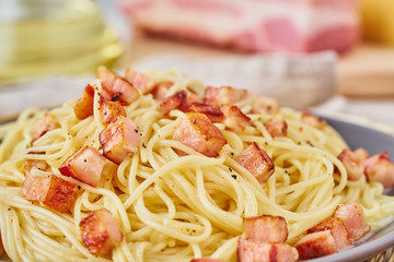 Close up carbonara pasta. Spaghetti with bacon, egg, parmesan cheese and cream sauce. Side view. Traditional italian cuisine.