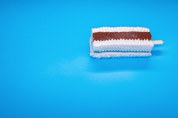 white color popsicle on a blue background