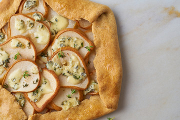 Pear galett with blue cheese, macro, savory pie, marble table, close up, copy space, top view