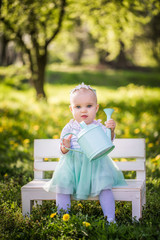 Adorable little girl sitting on a bench in a park