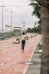 Fototapeta na wymiar woman cyclist riding a bike on bike path on the embankment